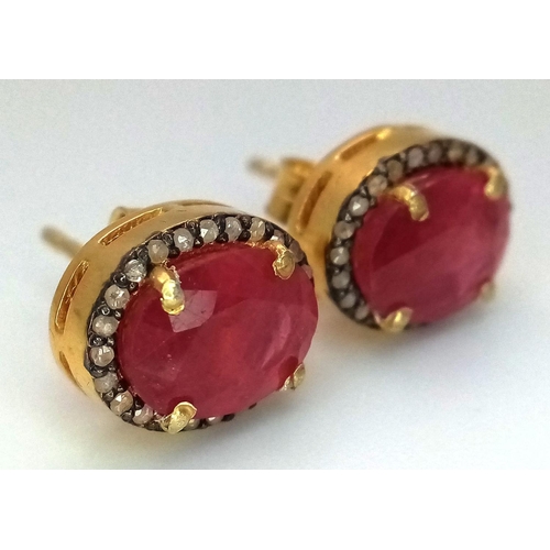 1221 - A Pair of Ruby and Diamond Earrings. Set in 925 gold plated silver. Oval cut rubies with diamond sur... 