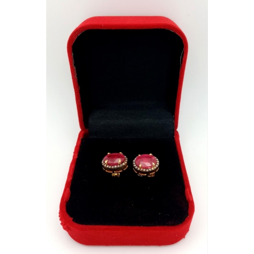 1221 - A Pair of Ruby and Diamond Earrings. Set in 925 gold plated silver. Oval cut rubies with diamond sur... 