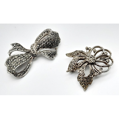 1655 - 2x silver Marcasite floral and bow brooches. Total weight 21.8G. Please see photos for details.