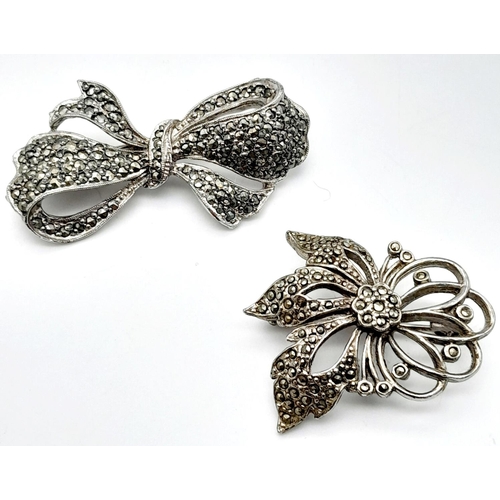 1655 - 2x silver Marcasite floral and bow brooches. Total weight 21.8G. Please see photos for details.