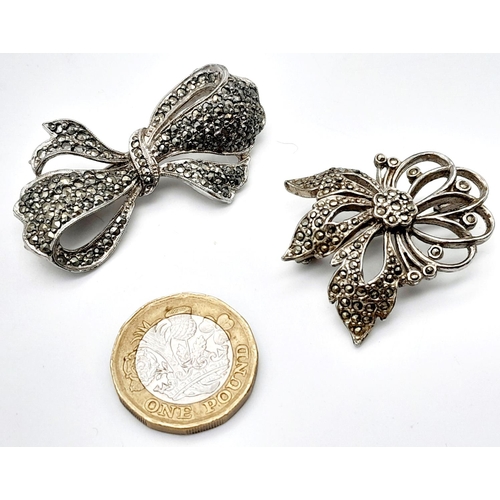 1655 - 2x silver Marcasite floral and bow brooches. Total weight 21.8G. Please see photos for details.