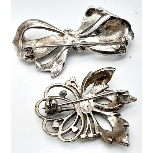 1655 - 2x silver Marcasite floral and bow brooches. Total weight 21.8G. Please see photos for details.