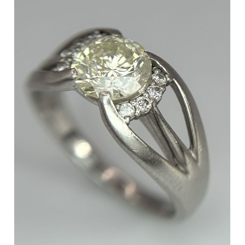 316 - A Stunning 900 Platinum 1.5ct (SI2) Tinted Yellow Diamond Ring. Brilliant round cut central diamond ... 