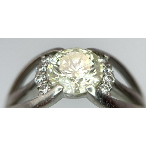 316 - A Stunning 900 Platinum 1.5ct (SI2) Tinted Yellow Diamond Ring. Brilliant round cut central diamond ... 