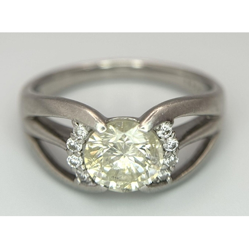 316 - A Stunning 900 Platinum 1.5ct (SI2) Tinted Yellow Diamond Ring. Brilliant round cut central diamond ... 