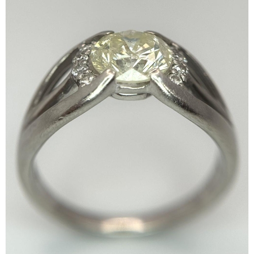 316 - A Stunning 900 Platinum 1.5ct (SI2) Tinted Yellow Diamond Ring. Brilliant round cut central diamond ... 