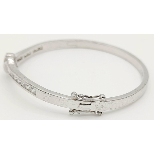 1000 - A STERLING SILVER STONE SET BANGLE - WITH DOUBLE SAFETY CATCH. 14.7G. SC5073