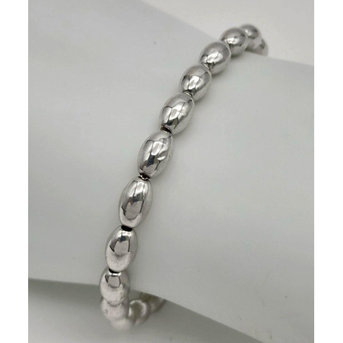 1007 - A STERLING SILVER BEAN SHAPED BRACELET. 3.6G. SC5074.
18CM.