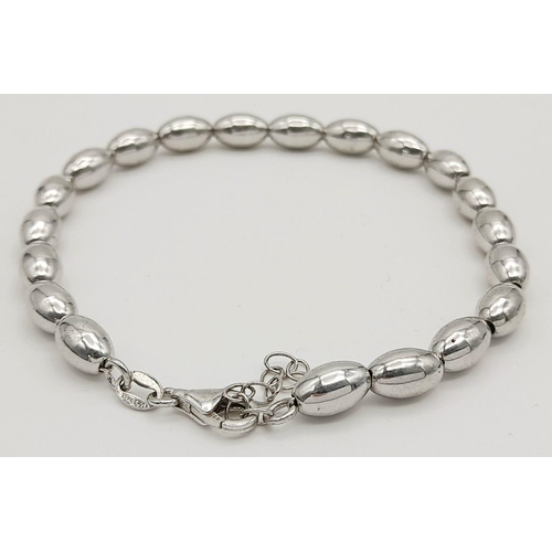 1007 - A STERLING SILVER BEAN SHAPED BRACELET. 3.6G. SC5074.
18CM.