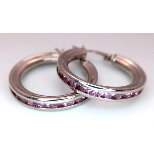 1056 - A PAIR OF STERLING SILVER PINK STONE SET HOOP EARRINGS. 6.4G.