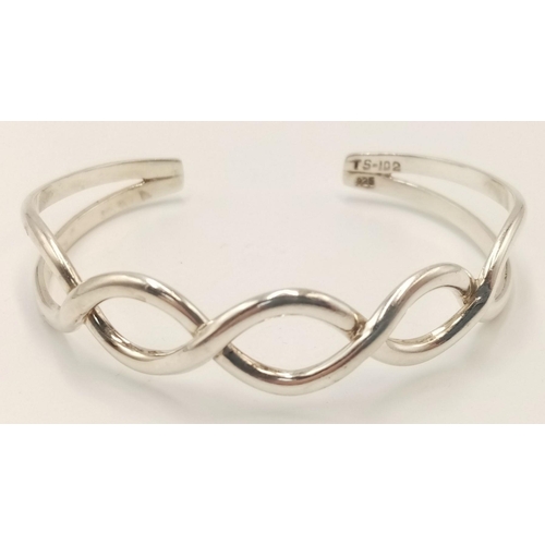 1084 - A Sterling Silver Celtic Design Knot Bangle. 6.1cm Inner Width. Weight 17.07 Grams