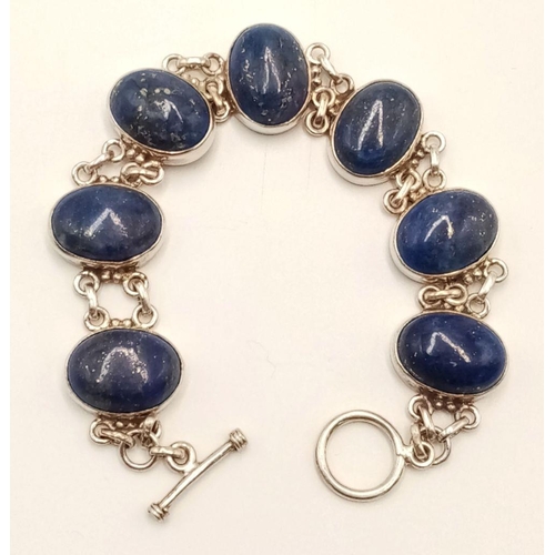 585 - A Vintage Sterling Silver, Lapis Lazuli Cabochon, T-Bar Bracelet. 19cm Length, Set with seven 1.5cm ... 