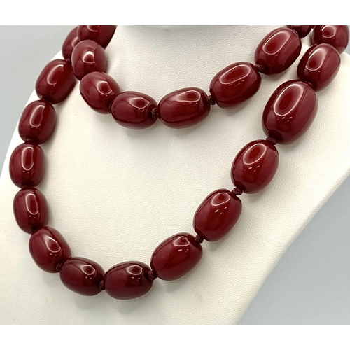 1391 - A graduated cherry resin necklace with matching drop earrings. Approx 101.5cm chain length, 4.5cm ea... 