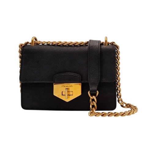 255 - A Prada Black Shoulder Bag. Saffiano leather exterior with gold-toned hardware, chain and leather st... 