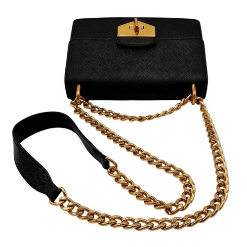 255 - A Prada Black Shoulder Bag. Saffiano leather exterior with gold-toned hardware, chain and leather st... 