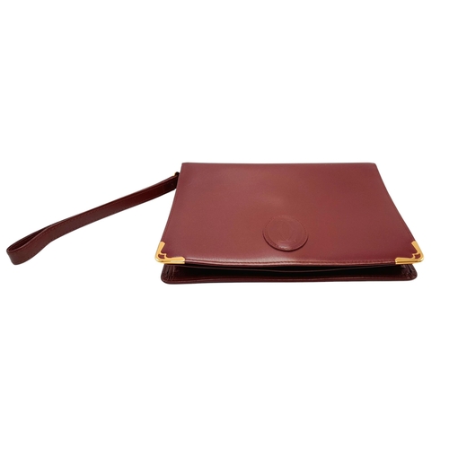 305 - A Cartier Burgundy Must de Cartier Wallet. Burgundy leather exterior, featuring gold-toned hardware ... 