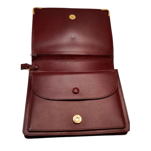 305 - A Cartier Burgundy Must de Cartier Wallet. Burgundy leather exterior, featuring gold-toned hardware ... 