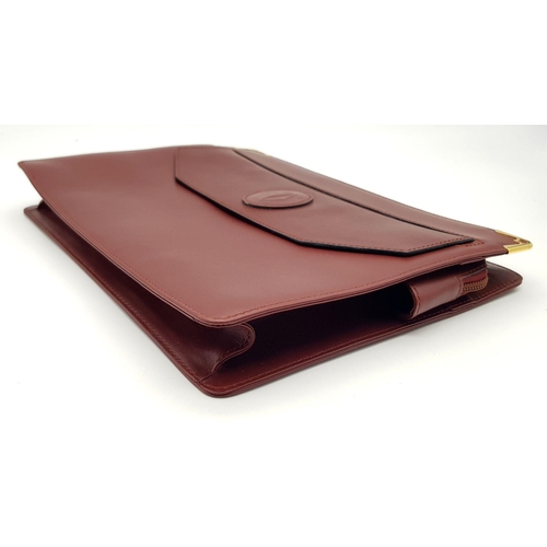 298 - A Cartier Burgundy Leather Toiletry Bag. Burgundy leather exterior with gold-toned hardware and snap... 