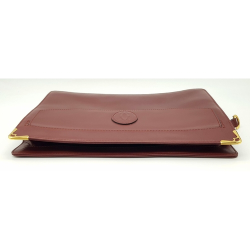 298 - A Cartier Burgundy Leather Toiletry Bag. Burgundy leather exterior with gold-toned hardware and snap... 