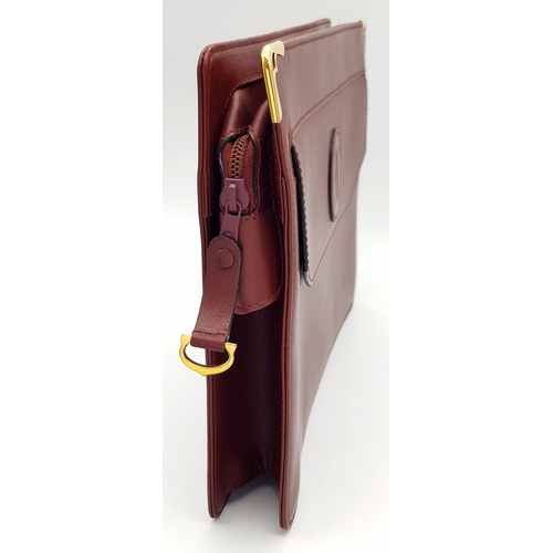 298 - A Cartier Burgundy Leather Toiletry Bag. Burgundy leather exterior with gold-toned hardware and snap... 