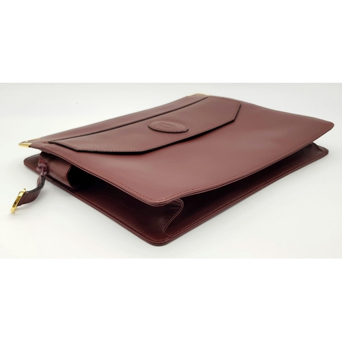 298 - A Cartier Burgundy Leather Toiletry Bag. Burgundy leather exterior with gold-toned hardware and snap... 