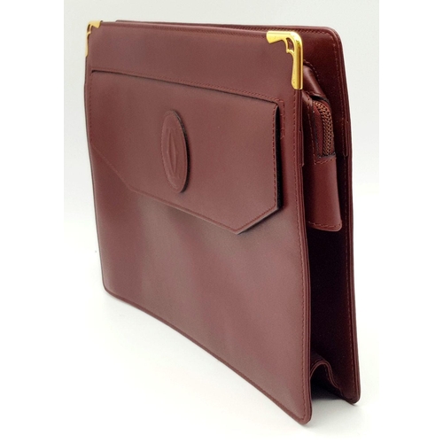 298 - A Cartier Burgundy Leather Toiletry Bag. Burgundy leather exterior with gold-toned hardware and snap... 