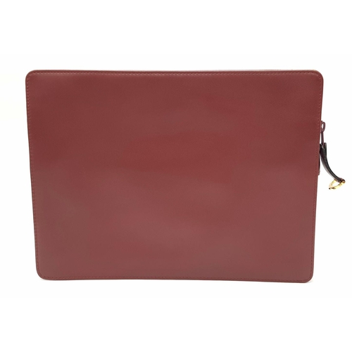 298 - A Cartier Burgundy Leather Toiletry Bag. Burgundy leather exterior with gold-toned hardware and snap... 