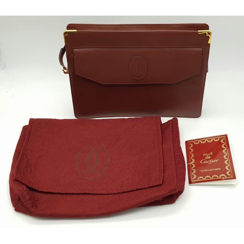 298 - A Cartier Burgundy Leather Toiletry Bag. Burgundy leather exterior with gold-toned hardware and snap... 