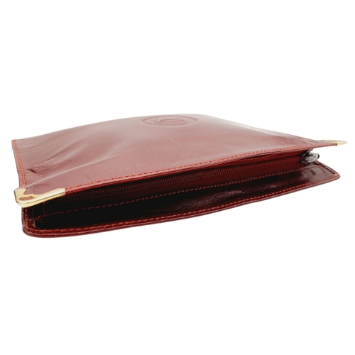 312 - A Cartier Burgundy Must de Cartier Pouch. Leather exterior with gold-toned hardware and a zip closur... 