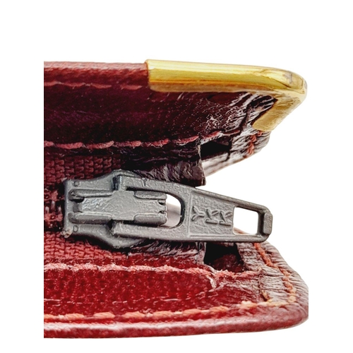 312 - A Cartier Burgundy Must de Cartier Pouch. Leather exterior with gold-toned hardware and a zip closur... 