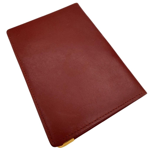 340 - A Cartier Burgundy Leather Passport Holder. Leather exterior with gold-toned hardware and an embosse... 