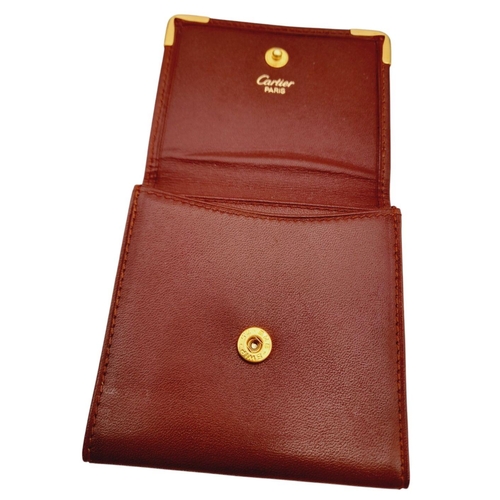 395 - A Cartier Paris Brown Leather Coin Wallet. Leather exterior with gold-toned hardware and snap button... 