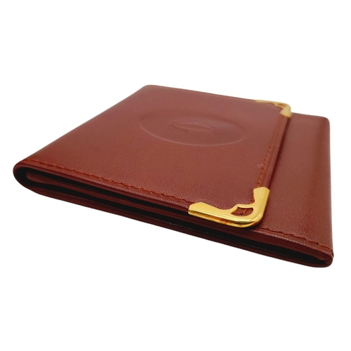 395 - A Cartier Paris Brown Leather Coin Wallet. Leather exterior with gold-toned hardware and snap button... 