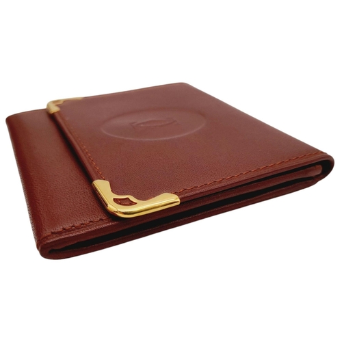 395 - A Cartier Paris Brown Leather Coin Wallet. Leather exterior with gold-toned hardware and snap button... 