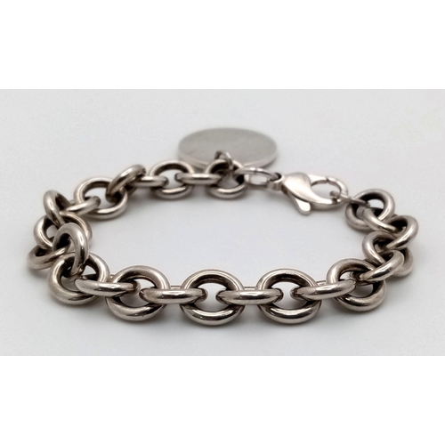 106 - A Vintage Tiffany Sterling Silver Bracelet with Tiffany Circular Charm. 16cm. 38g. Comes with a Tiff... 