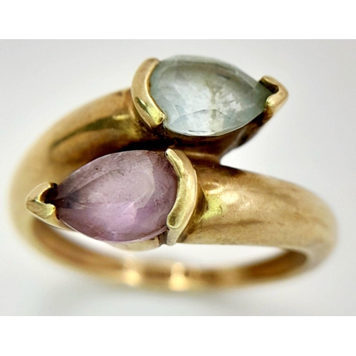 284 - A VERY ATTRACTIVE 9K GOLD STONE SET DRESS RING IN CROSSOVER STYLE .    2.6gms      size N/Q