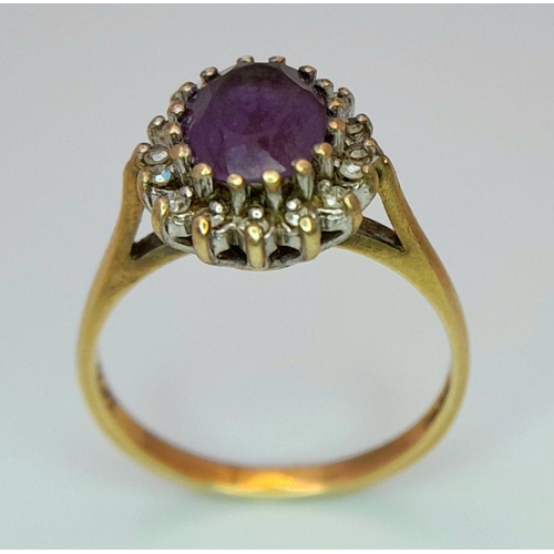 353 - A 9K GOLD RING WITH AMETHYST CENTRE STONE SURROUNDED BY A HALO OF DIAMONDS.   2.4gms    size N