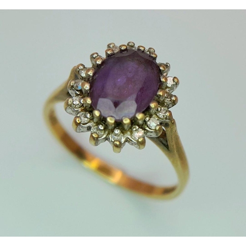 353 - A 9K GOLD RING WITH AMETHYST CENTRE STONE SURROUNDED BY A HALO OF DIAMONDS.   2.4gms    size N