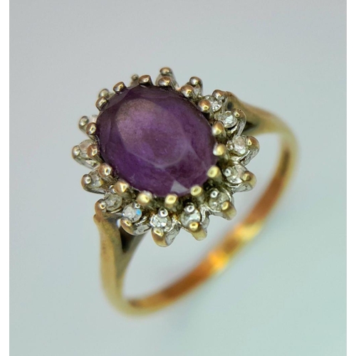 353 - A 9K GOLD RING WITH AMETHYST CENTRE STONE SURROUNDED BY A HALO OF DIAMONDS.   2.4gms    size N