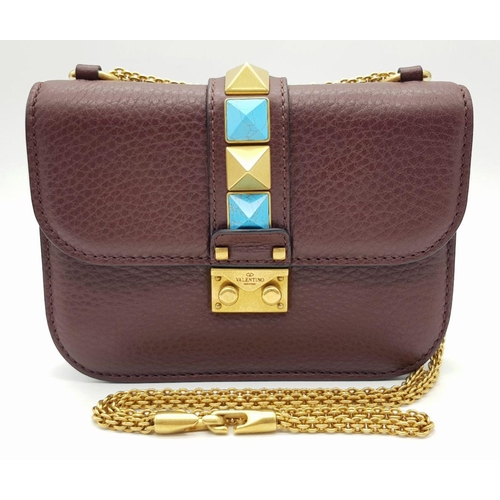 53 - A Valentino Rockstud Burgundy Leather Crossbody Bag. Leather exterior with gold-toned hardware, chai... 