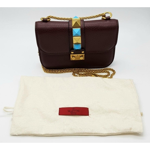 53 - A Valentino Rockstud Burgundy Leather Crossbody Bag. Leather exterior with gold-toned hardware, chai... 