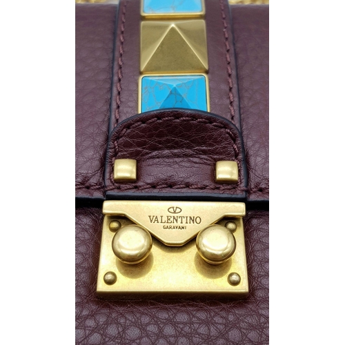 53 - A Valentino Rockstud Burgundy Leather Crossbody Bag. Leather exterior with gold-toned hardware, chai... 