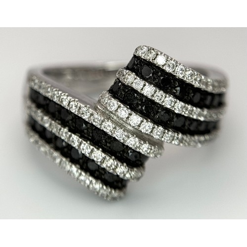 50 - A 14K WHITE GOLD, BLACK AND WHITE DIAMOND CROSSOVER RING. SOPHISTICATED, LOVELY DESIGN. 7.8G. SIZE N... 