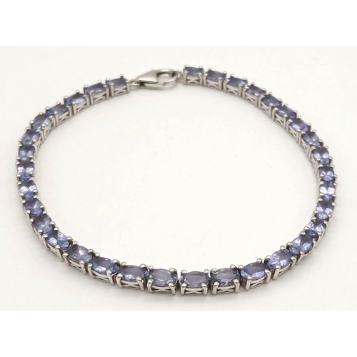 382 - A Sterling Silver Tanzanite Set Tennis Bracelet 19.5cm Length. Set with Thirty-Four 5mm Oval Cut Tan... 