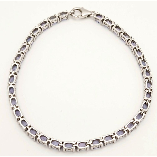 382 - A Sterling Silver Tanzanite Set Tennis Bracelet 19.5cm Length. Set with Thirty-Four 5mm Oval Cut Tan... 