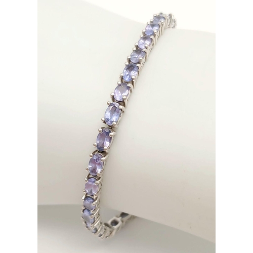 382 - A Sterling Silver Tanzanite Set Tennis Bracelet 19.5cm Length. Set with Thirty-Four 5mm Oval Cut Tan... 