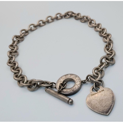 451 - A Tiffany and Co. Sterling Silver Chain with Toggle Clasp and Heart Charm. 36cm. 76g weight.