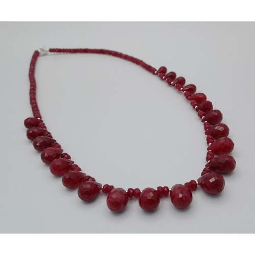 614 - A 925 silver single strand necklace with 100ct ruby gemstone drops and ruby beads, finished with a s... 