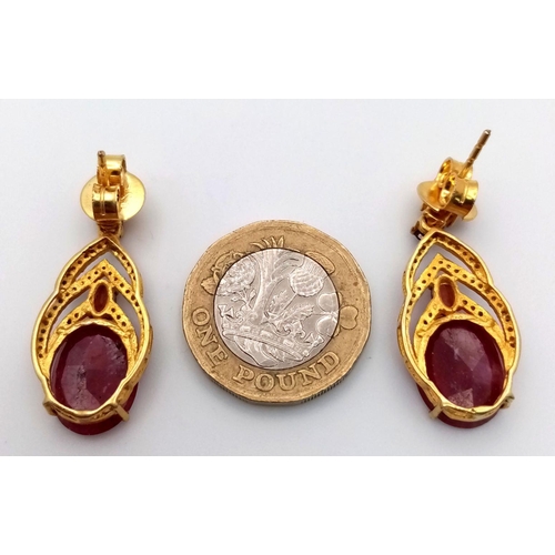 675 - A pair of 925 silver earrings with 9ct rubies and 0.60ct diamond accents, finished in yellow silver.... 