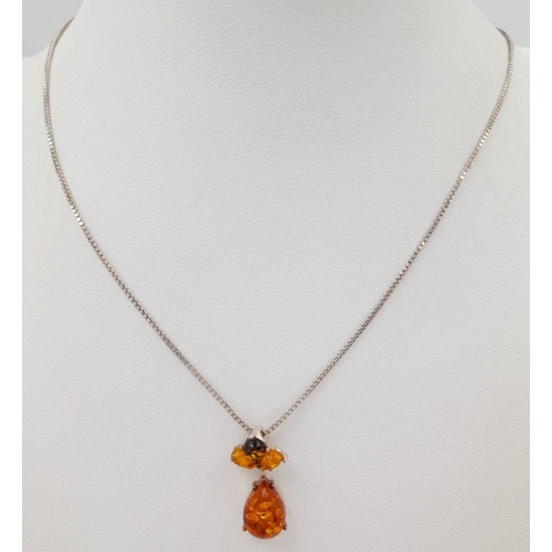 700 - A ‘HOBBS’  AMBER and SILVER PENDANT. Having different shades of Amber set in SILVER and mounted on a... 